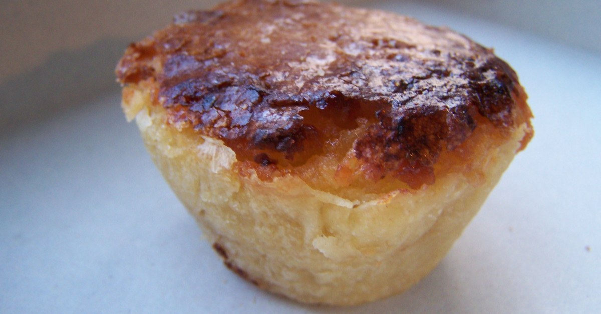 Pastel de feijão de Torres Vedras, croûte dorée fendue sur sa garniture d'amande et de haricot blanc