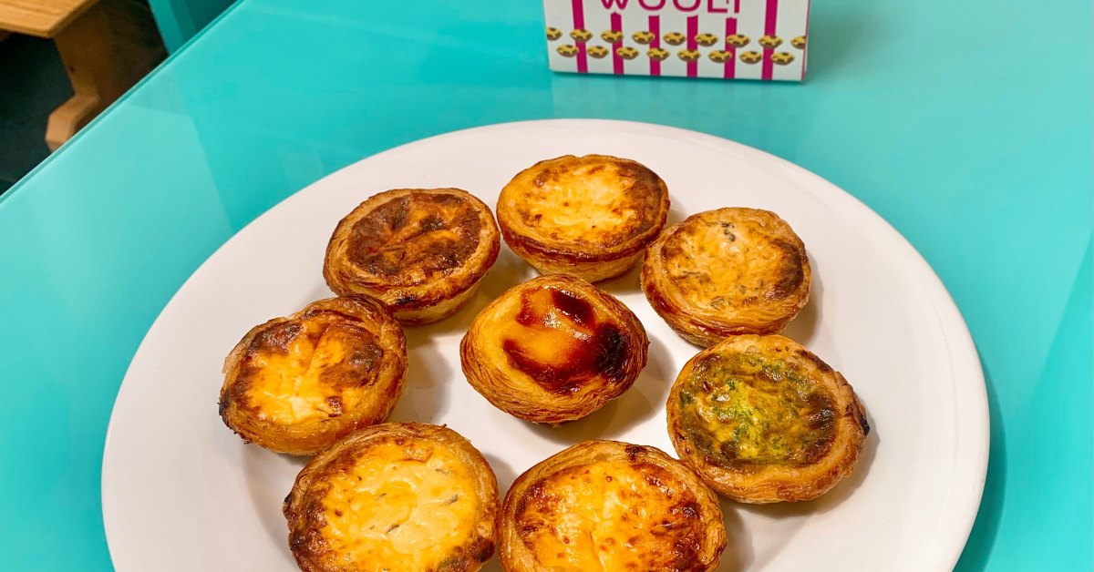 Pastéis de nata Wooly dorés et tachetés de brun, sur une assiette blanche